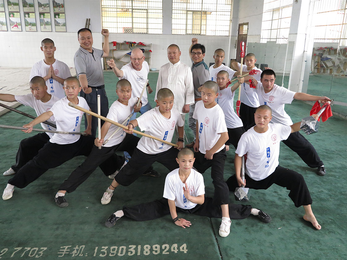 With the Head Buddha to his left, "Mr. Joke" is surrounded by the Shaolin Temple Kung Fu boys in Dengfeng.