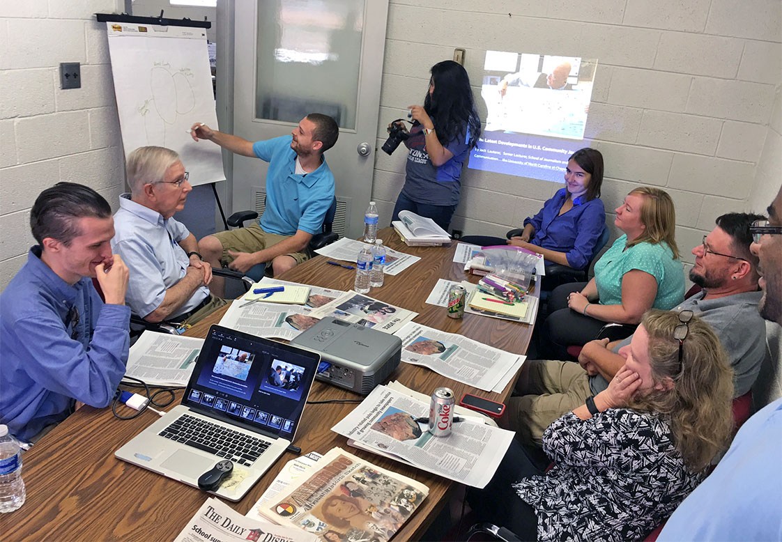 Mapping it out, sports editor Ryan Leger maps out the coverage area of the Dispatch as workshop participants look on, left to right, Ryan Hedrick, David Irvine, Diana Lopez, Allison Tretina, Tiffany Hudson, Mark Dolejs, Nancy Wykle and Carlton Koonce. (Jock Lauterer photo)