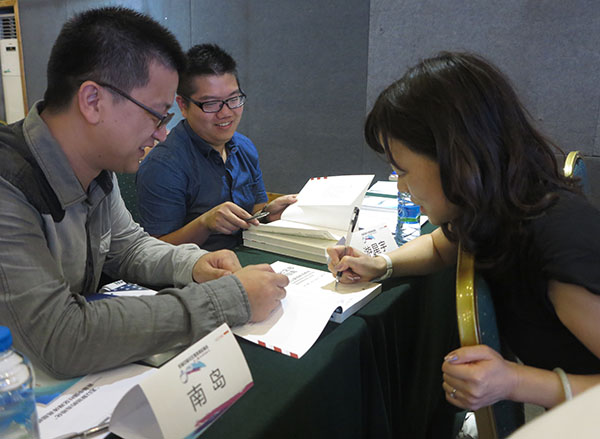 Prof. Chen Kai (Karen) signing her book at last summer's conference on Community Journalism in Shenzhen. (Jock Lauterer photo)