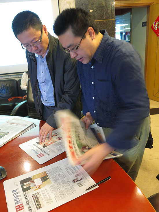From last year's teaching trip: My Chongqing colleauge, Prof. Li Ren, right, huddling with a local newspaper editor about their new community newspaper in that huge southwest China city. (Jock Lauterer photo)