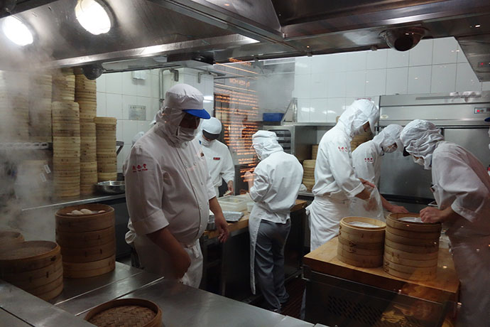Clad head to foot in white, Beijing prep cooks and dumpling cooks make dumplings.