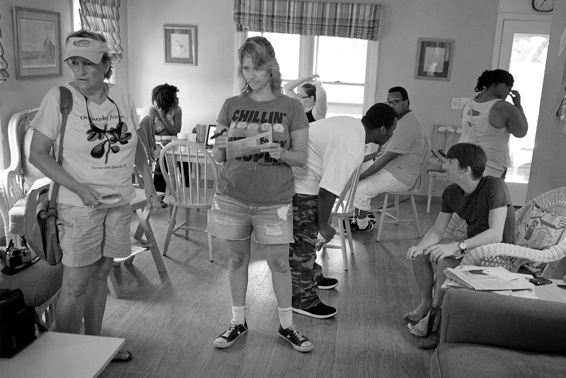 Young VOICE staffers scramble as Partners for Youth Opportunity Executive Director Julie Wells, center, hands out story assignments. (Jock Lauterer photo)