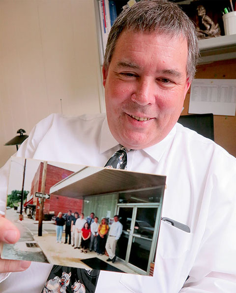 THAT WAS THEN…THIS IS NOW. Eastern Wake News Editor Johnny Whitfield holds a photo that I made at the very first Community Journalism Roadshow workshop 15 summers ago, June 2001, when Johnny was serving as editor of the Mitchell News-Journal in Spruce Pine. 